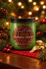 Cranberry Wreath Candle in a green jar surrounded by holiday decorations and pinecones with festive lights in the background.