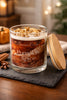 Clear glass jar candle with white wax and crumb-like topping bearing a label that reads Phoenix Crafted Pumpkin Spice.