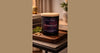 Phoenix Crafted cedarwood candle in a grounded natural-wood landscape composition.