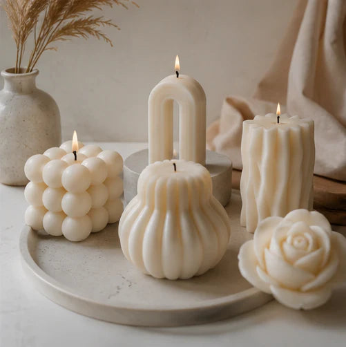 Sculptural and vessel candles arranged as decorative home accents.