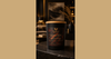 Phoenix Crafted Golden Santal candle in a warm creamy-sandalwood landscape composition.