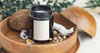 Natural fragrance oils for candles 2026 showcased in a stylish black jar on a wooden plate with natural decor.