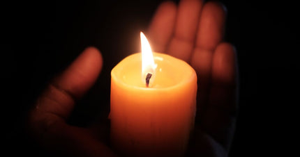 A supervised candle on a clear heat-resistant surface for a candle safety guide.