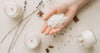 Natural soy wax candles 2026 with hand holding salt and decorative elements on a table.