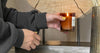 A hand holding a relaxing scented candle at home, representing the best scented candles for home 2026.