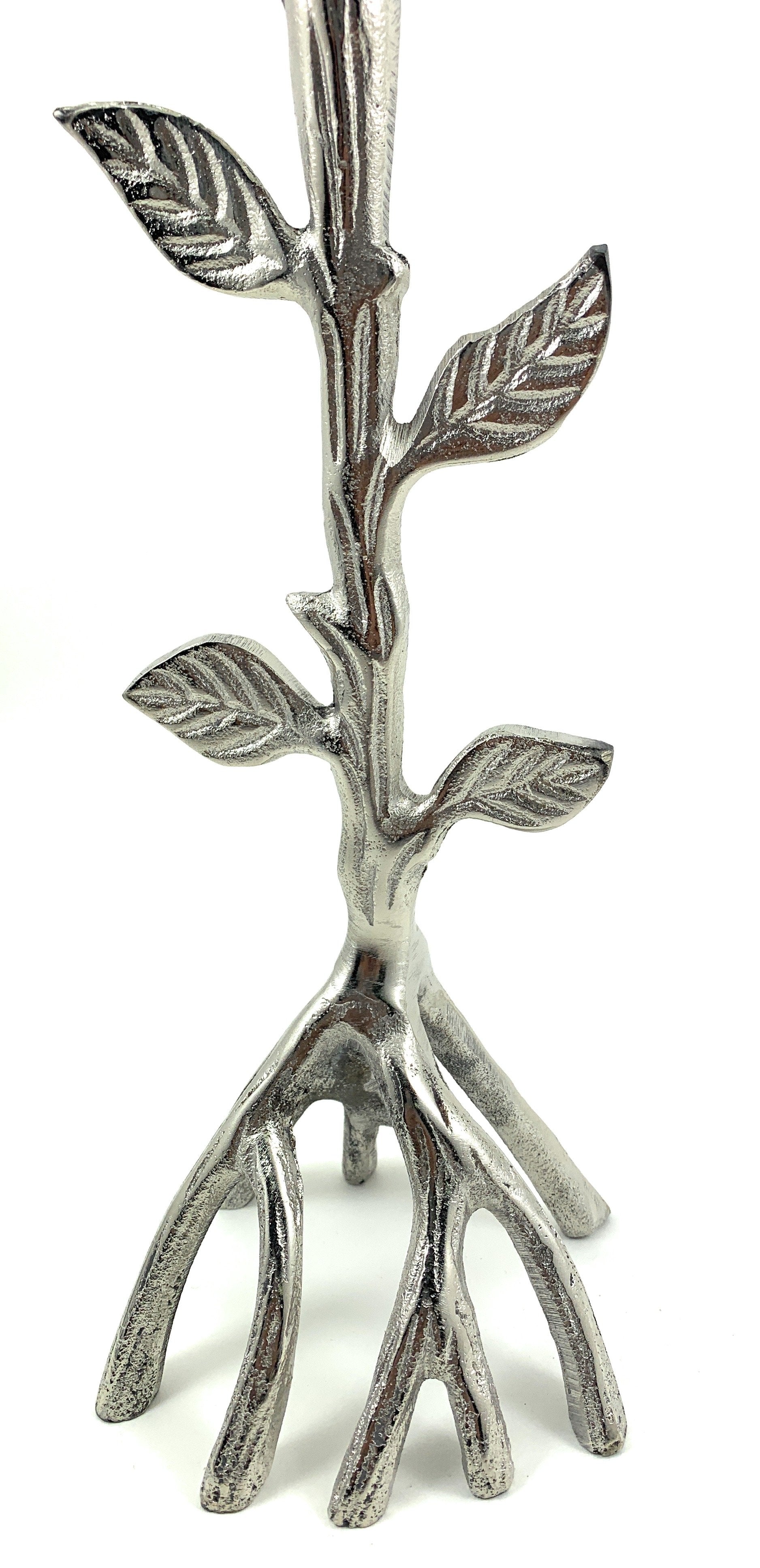 Silver-toned tree-branch candle holder with raised leaf details and a sculptural root-like base.