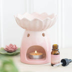 Pink water lily oil burner with tealight and essential oil, perfect for calming scents and home decor.