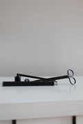 Candle Accessories including a black candle snuffer and wicks trimmer on a white surface for candle care.
