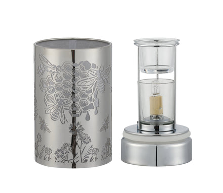 Silver cylindrical metal shade with laser-cut honeybee and floral pattern at left.