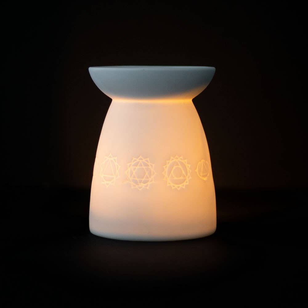 White Ceramic Seven Chakra Tealight Wax Warmer lighting up with chakra designs.