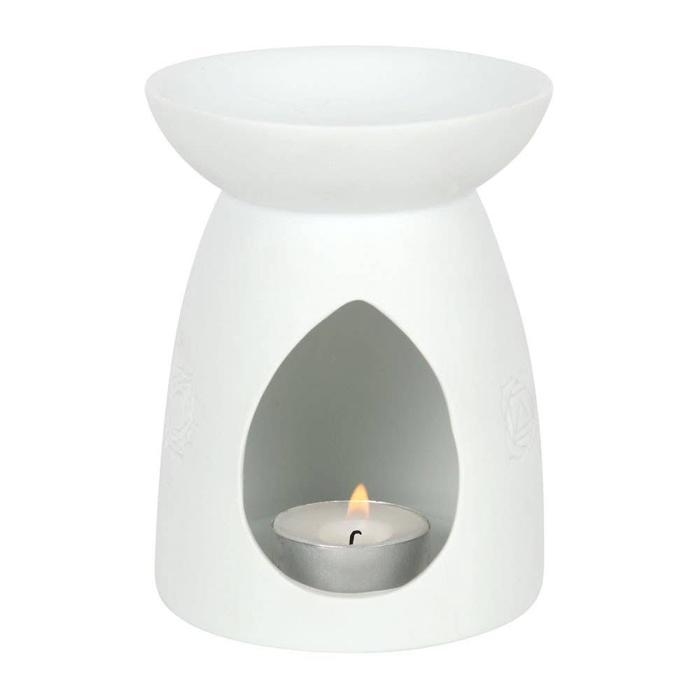 White ceramic tea-light wax warmer with shallow bowl top, teardrop front opening revealing a lit metal tealight and small flame.