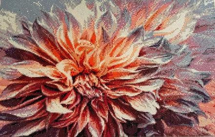 Close-up diamond painting of a dahlia with layered petals in orange, coral, maroon, pink and gray using round faceted drills on a canvas grid.
