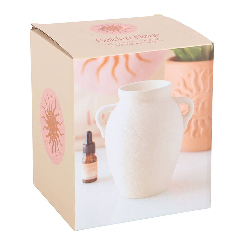 Elegant vase shaped oil burner and wax warmer in white packaging with decorative design.