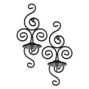 Pair of dark metal scrollwork wall sconces with round candle trays and rear hanging loops on a white background.