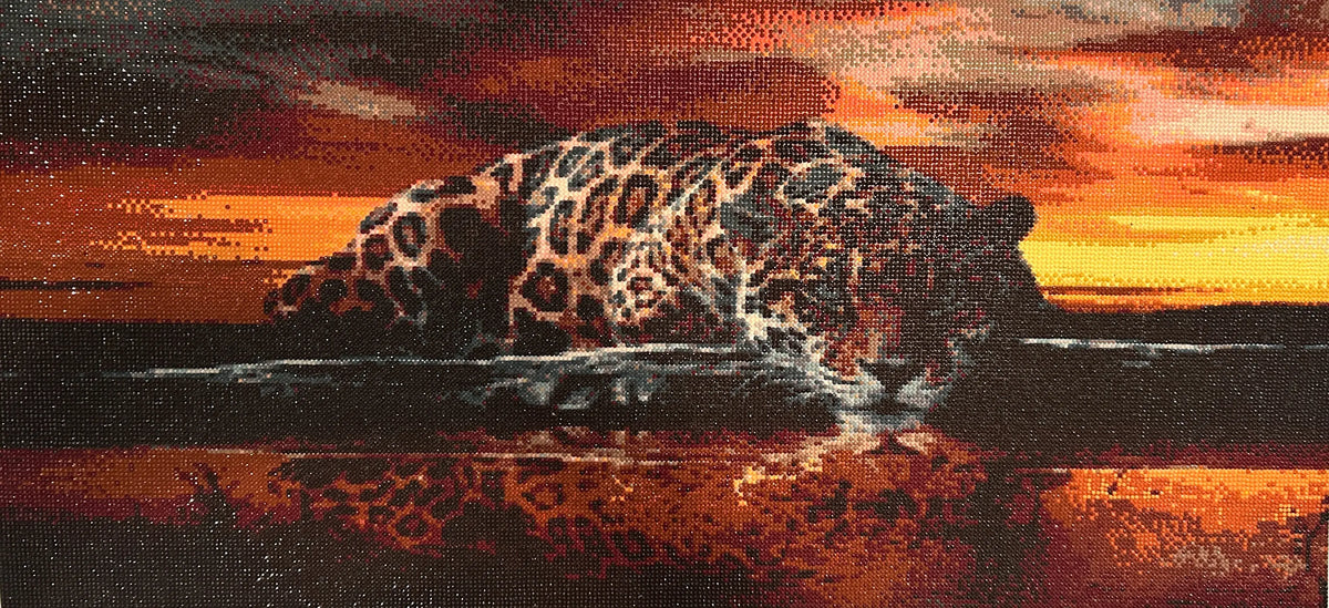 Sunset Watcher Diamond Painting of a leopard by the water at sunset with vibrant colors and lifelike detail.