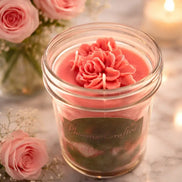 Alluring Berry Candle in a clear jar with floral decorations, surrounded by pink roses and candlelight.