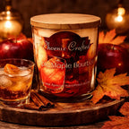 Apple Maple Bourbon Candle displayed with an autumn-themed scene, featuring apples and cinnamon sticks.