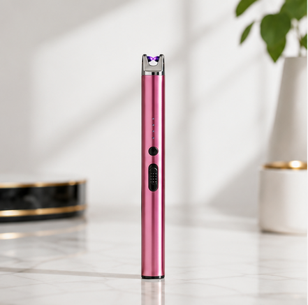USB Rechargeable Arc Lighter in pink standing on a table with a plant in the background.