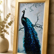 Azure Crest Peacock Diamond Painting displayed in a gold frame against a stone wall.