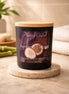 Matte black jar candle with a light wooden lid, front label reading "Phoenix Crafted Bamboo & Coconut" with halved coconuts.