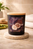 Matte black jar candle with a light wooden lid, front label reading "Phoenix Crafted Bamboo & Coconut" with halved coconuts.