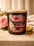 Bergamot Rose & Sandalwood Candle in a black container with a wooden lid, surrounded by fresh roses and lemon.