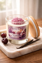 Black Cherry Vanilla Candle in a jar with pink wax and wooden lid, showcasing rich cherry and vanilla scents.