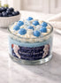 Blueberry Cream Pie Candle in a glass jar with blue and cream frosting decoration.