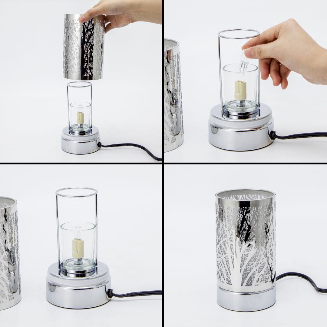 Chrome cylindrical wax warmer with tree-branch cutout shade, clear glass inner cylinder, small clear bulb and round chrome base on white background