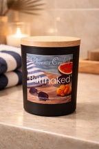 Buttnaked Candle on a marble countertop with tropical fruit design and wooden lid, perfect for summer scents.