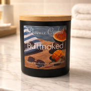 Butt Naked candle in a matte black jar with a wood lid on a light marble counter.