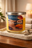 Butt Naked candle in a clear lidded glass jar on a marble tray with a mango-and-coconut label.