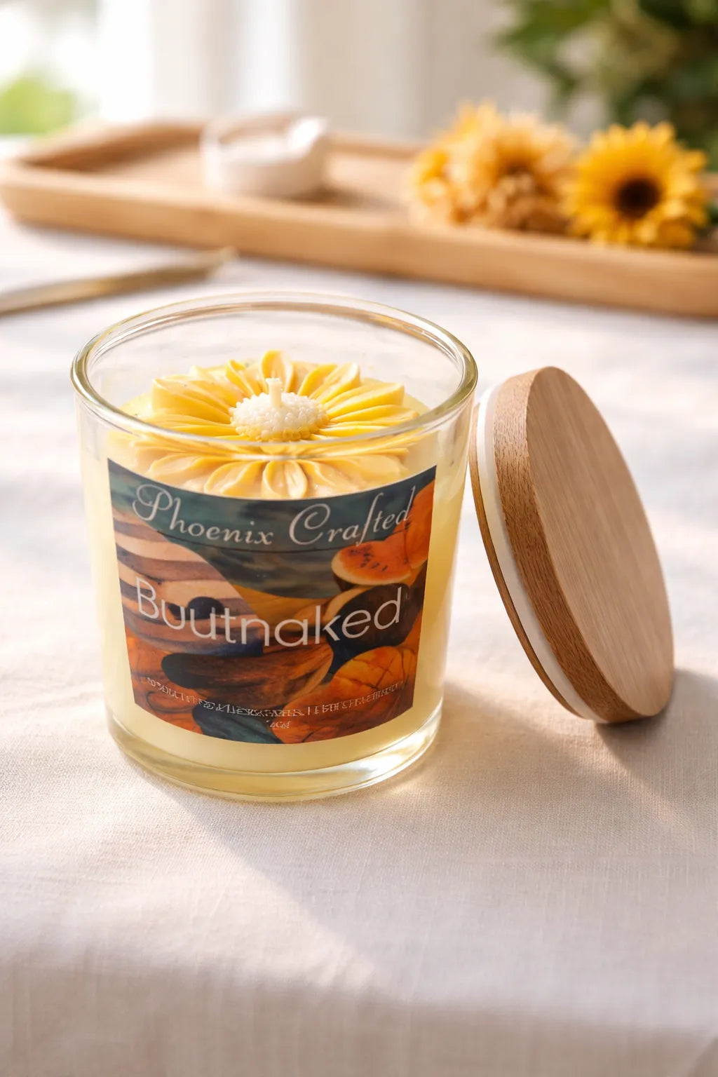 Buttnaked Candle in a glass jar with floral decoration, evoking tropical fruit scents and summer vibes.