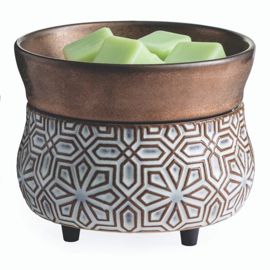 Bronze-and-cream ceramic wax warmer with a raised geometric pattern and a top dish holding pale green wax cubes.