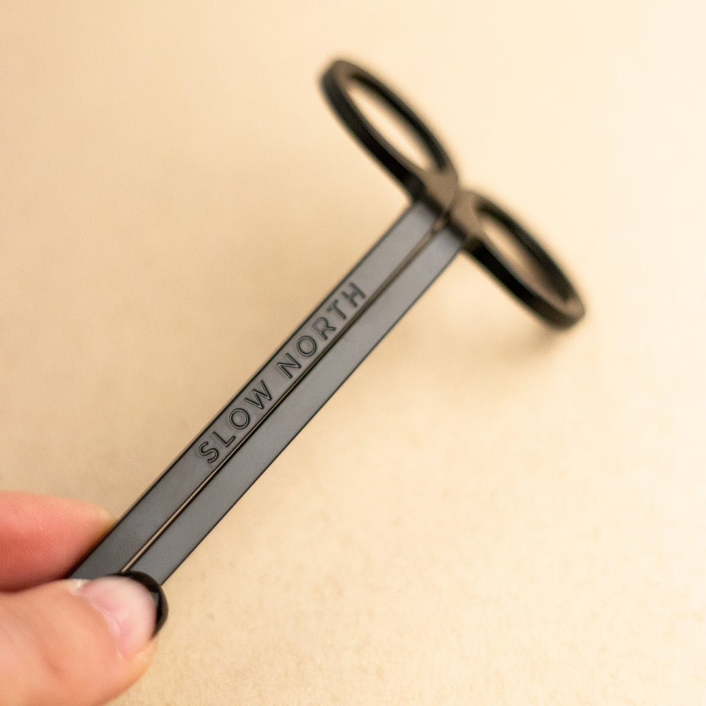 Candle care tool set featuring a stylish black wick trimmer labeled 'SLOW NORTH', ideal for candle maintenance.