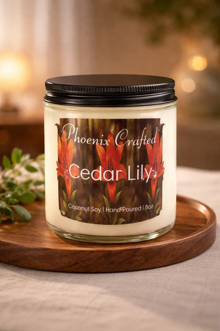 Cedar Lily Candle in a glass jar with vibrant floral label on a wooden tray.