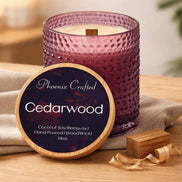 Textured purple glass candle with cream wax and visible wood wick, wooden lid propped showing the readable 'Cedarwood' label.