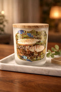 Enchanted Forest Candle in a decorative glass jar with a wooden lid, showcasing floral and woodland imagery.