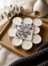 Pack of 10 hand-poured eucalyptus tealights arranged on a wooden tray with a cozy aesthetic.
