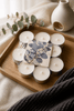 Pack of 10 hand-poured eucalyptus tealights arranged on a wooden tray with a cozy aesthetic.