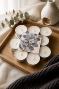 Pack of 10 hand-poured eucalyptus tealights arranged on a wooden tray with a cozy aesthetic.