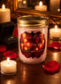 Pale pink candle in a clear jar with screw-top lid labeled 'Falling For You,' surrounded by red rose petals, tealights, and an open ring box on wood.