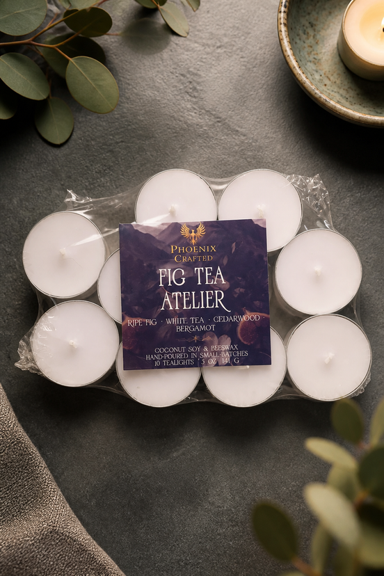 Fig Tea Atelier tealights arranged around their branded package on a dark stone surface.