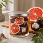 Grapefruit & Mangosteen Candle with vibrant grapefruit and mangosteen displayed on a kitchen counter.