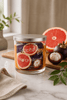 Grapefruit & Mangosteen Candle with vibrant grapefruit and mangosteen displayed on a kitchen counter.