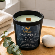 Lit Eucalyptus Mint Steam candle with a full warm glow surrounded by eucalyptus and mint-inspired spa decor.