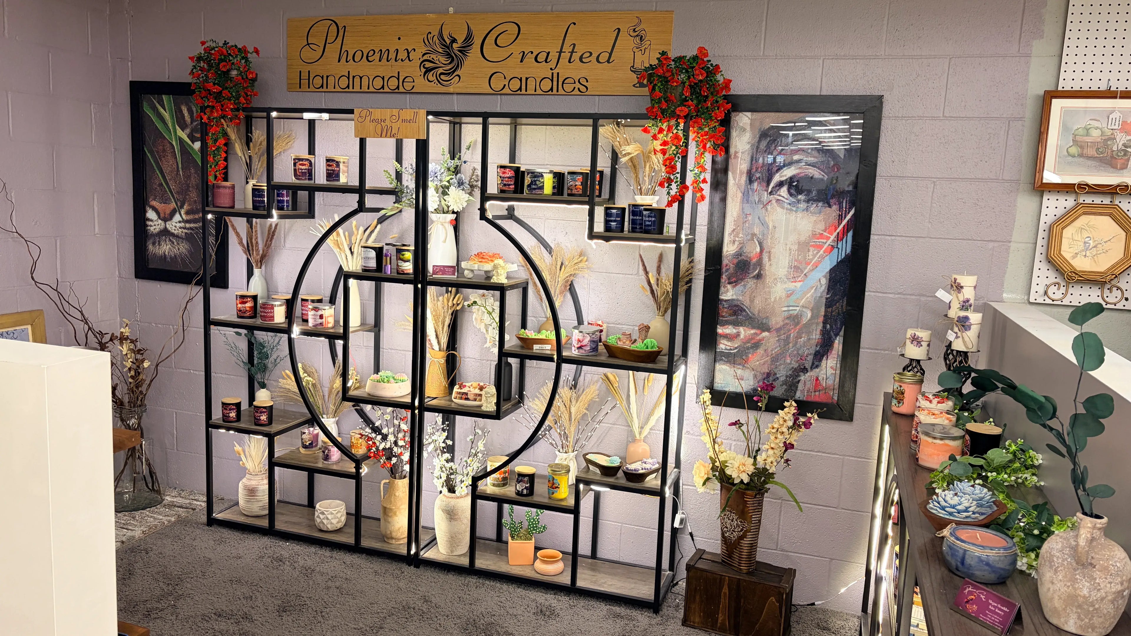 Display of candles and decorative items in a store with 'Phoenix Crafted Candles' sign.