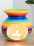 Rainbow Wax Melt Essential Oil Burner Warmer with a colorful striped design and lit tea light candle inside.