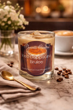 Iced Cappuccino Brûlée Candle displayed on a marble table with coffee beans and a spoon.