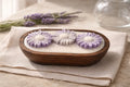 Lavender Candle with lavender flowers in a wooden dish, creating a serene and calming atmosphere for relaxation.